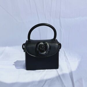 Elegant Black Handbag with Floral Accent